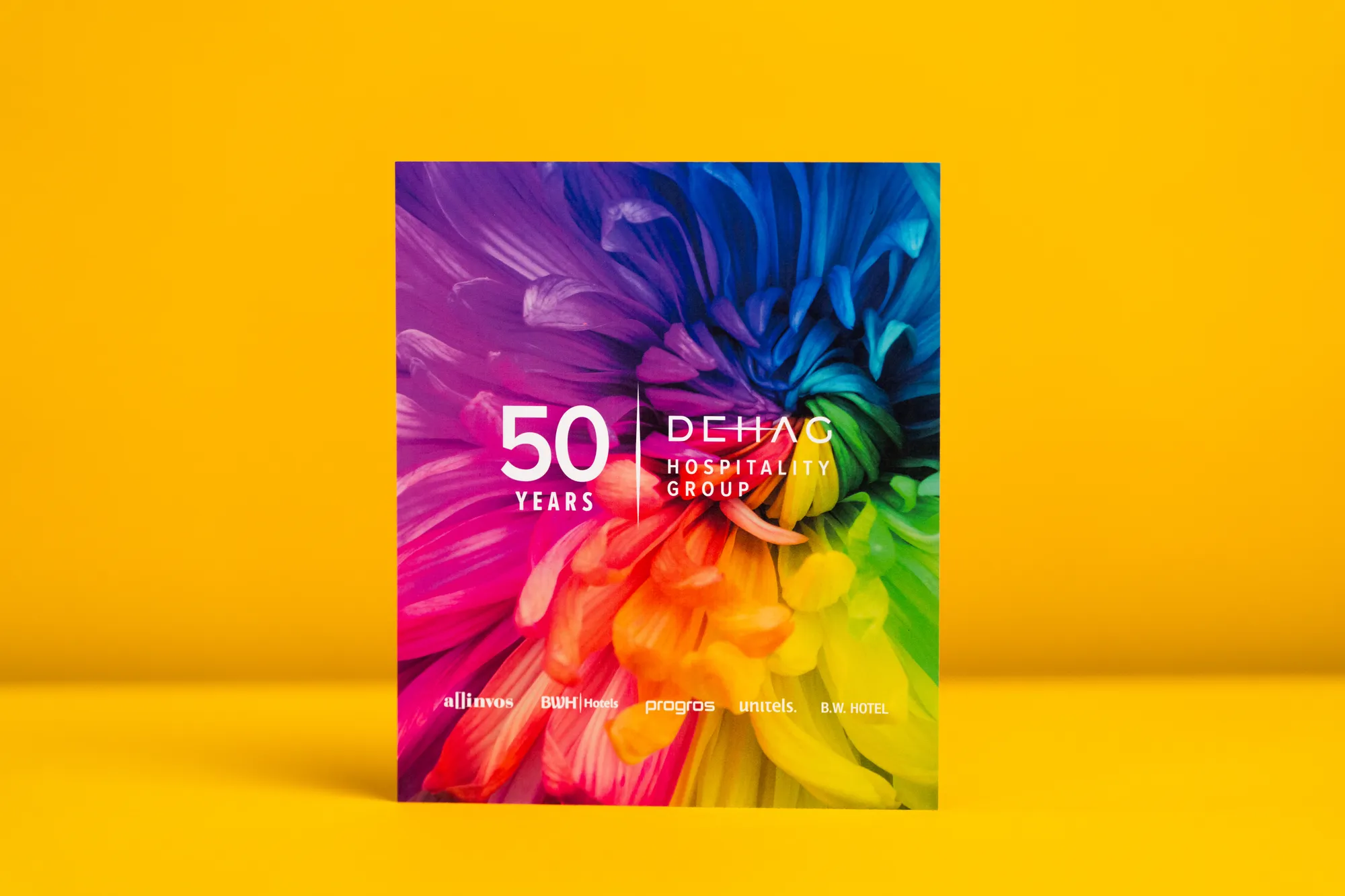 Karte mit einer farbenprächtigen Blüte und „50 Years“ auf gelbem Grund.