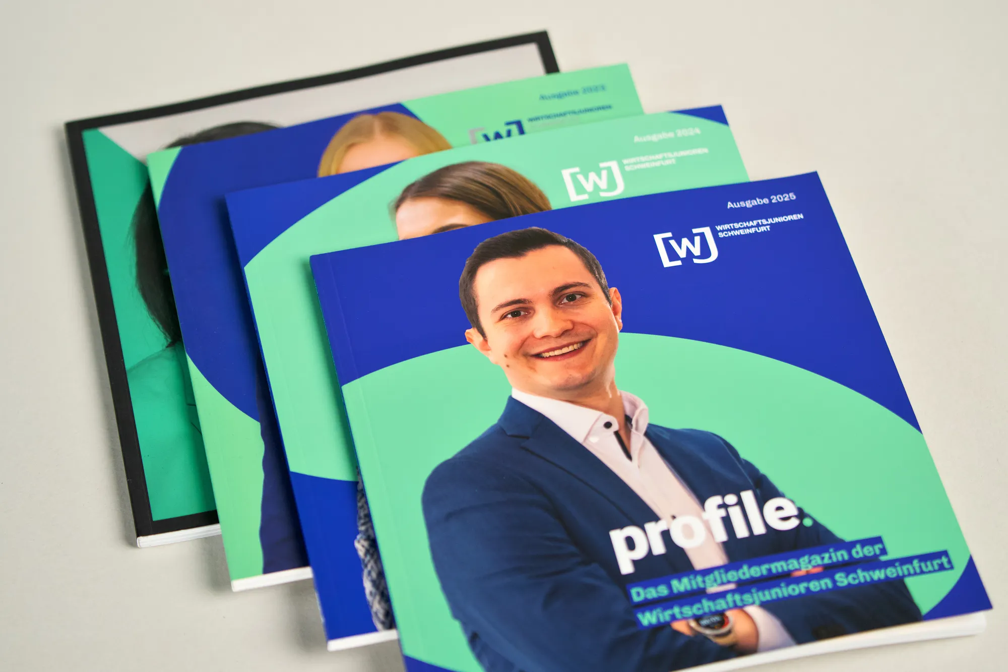 Mehrere quadratische Magazine „profile“ der Wirtschaftsjunioren, aufgefächert.