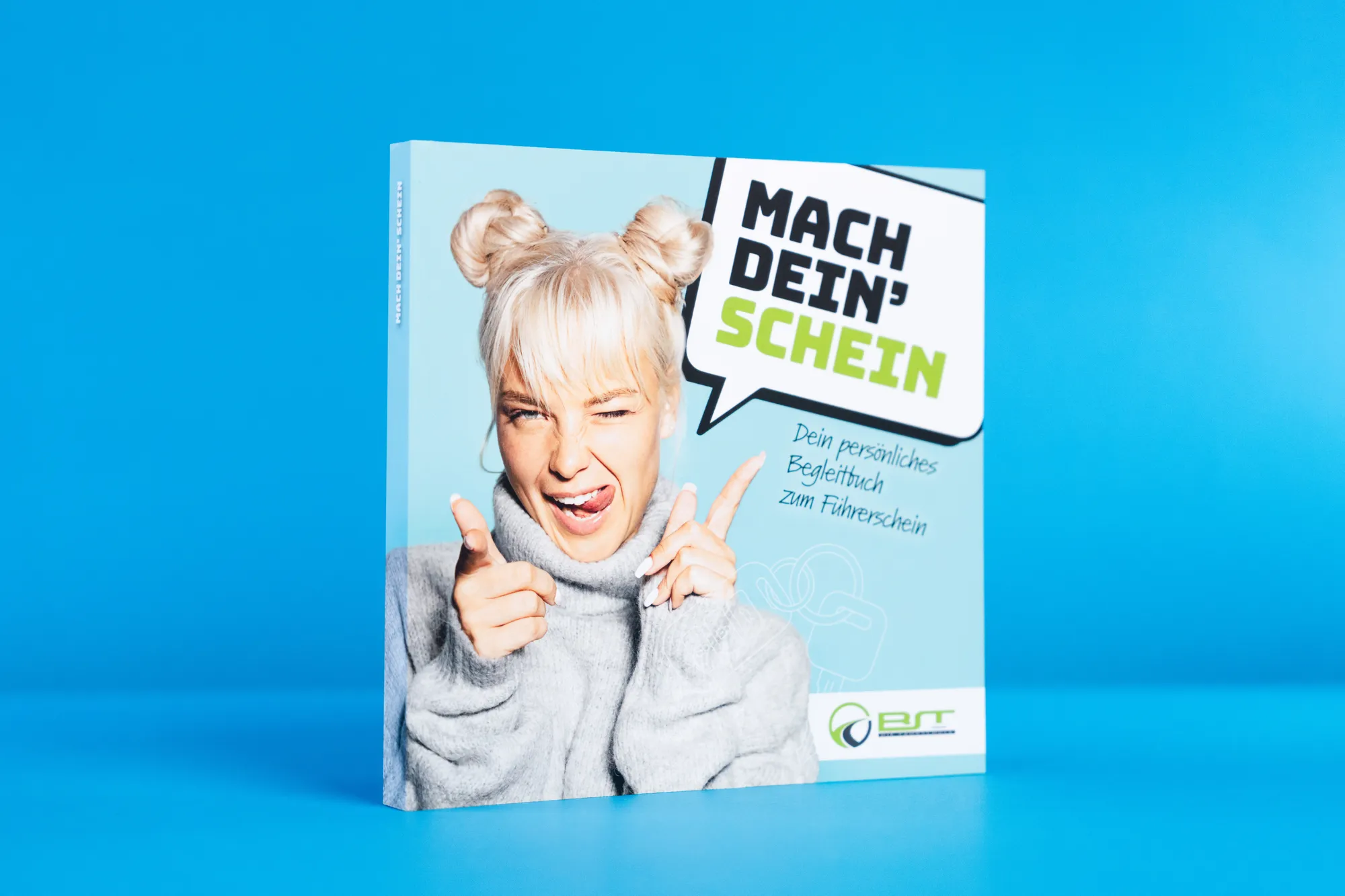 Quadratisches Buch „Mach dein’ Schein“ mit lachender junger Frau auf dem Titel vor blauem Grund.
