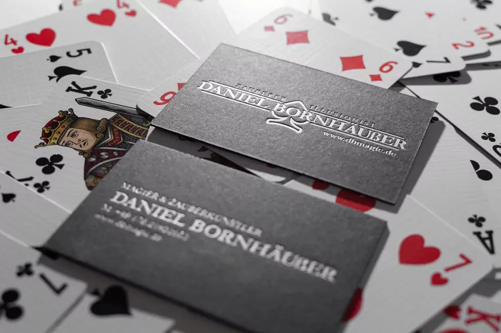 Zwei schwarze Visitenkarten mit matter silberner Heißfolienprägung „Daniel Bornhäußer“.