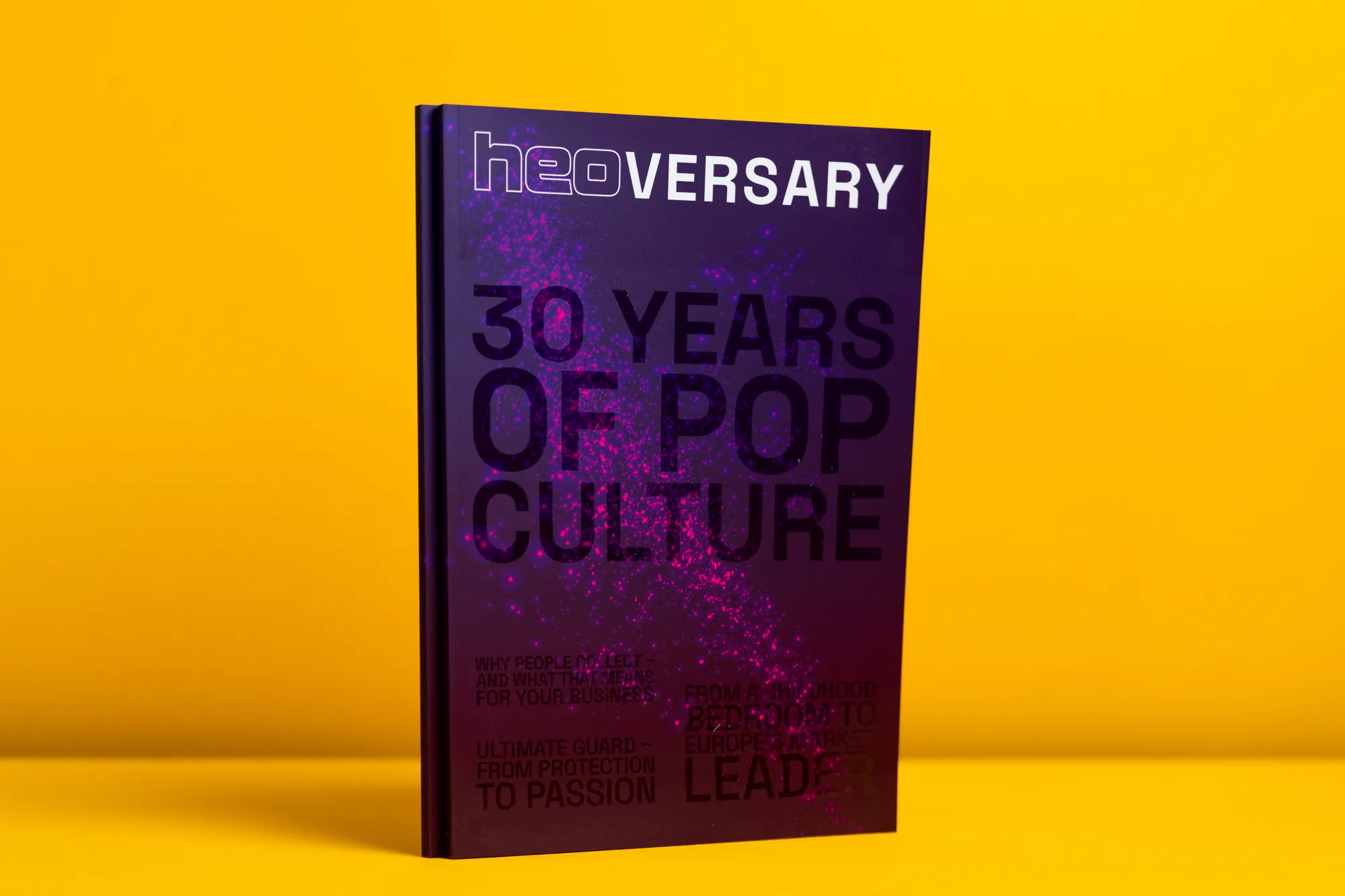 Violettes Softcover „30 Years of Pop Culture“ mit glänzendem UV-Relieflack vor gelbem Grund.