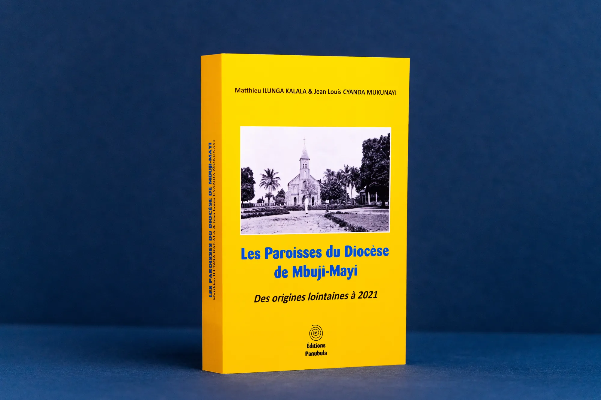 Gelbes Taschenbuch mit glänzendem Umschlag und historischem Kirchenfoto vor blauem Grund.